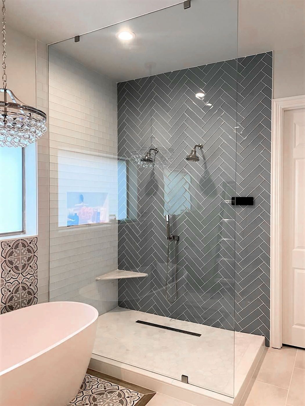 A refinished bathroom by Footprints Bath and Tile Lawrenceville / Sugar Hill with modern, stylish tiling and vaulted ceilings.