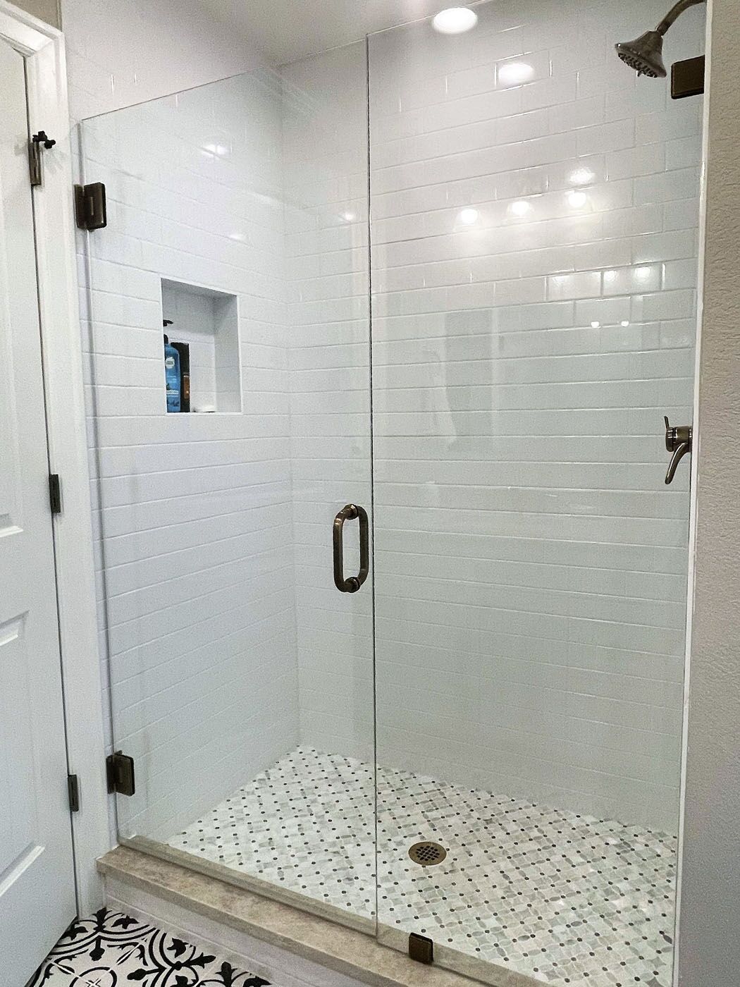 A newly renovated bathroom with tile on the floors, shower walls, and shower floors.